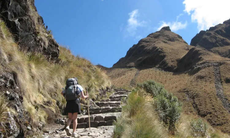 Beautiful girl climbing stairs of Inca trail